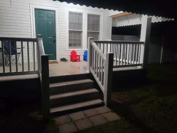 Black aluminum porch handrail fitted to brick steps