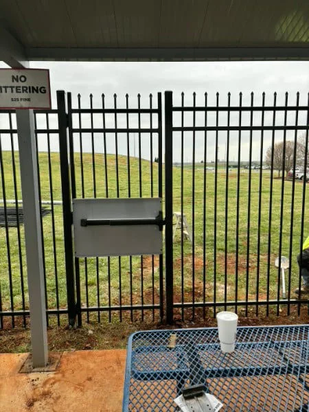 Black aluminum fence and gate at a paved entrance