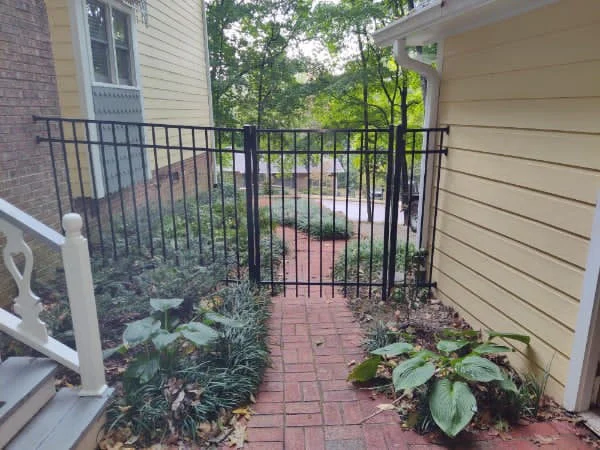 Black aluminum fence set into planted landscaping
