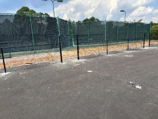 Black vinyl coated chain link fence along a lawn