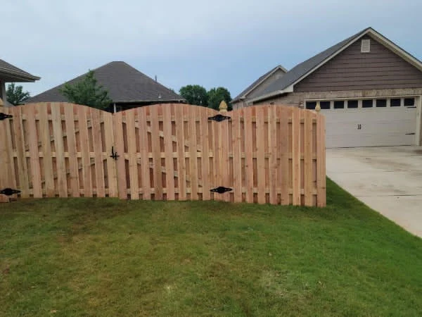 Board to board arch fence running along a residential back yard boundary