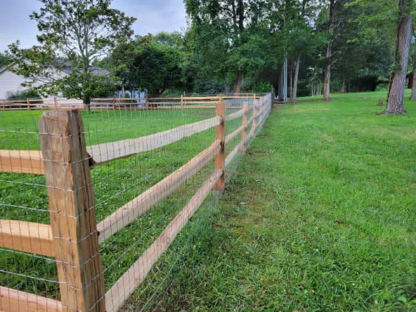 Three rail cedar split rail fence with welded wire along a property line