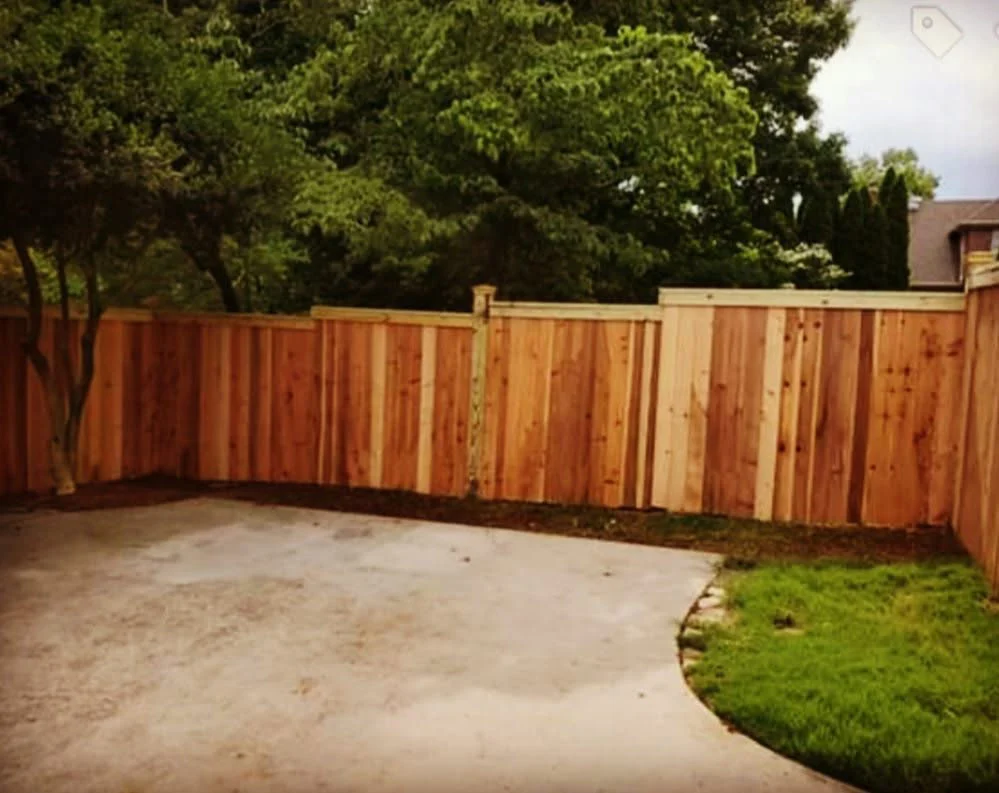 Stained wood privacy fence meeting a garage corner
