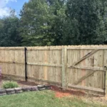 Wood fence with a walk gate and black strap hinges