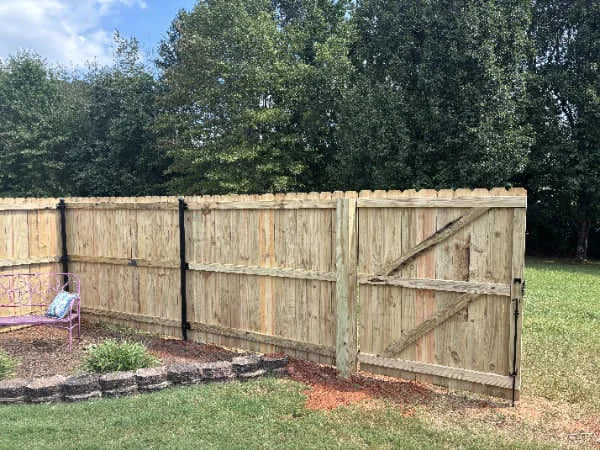 Wood fence with a walk gate and black strap hinges