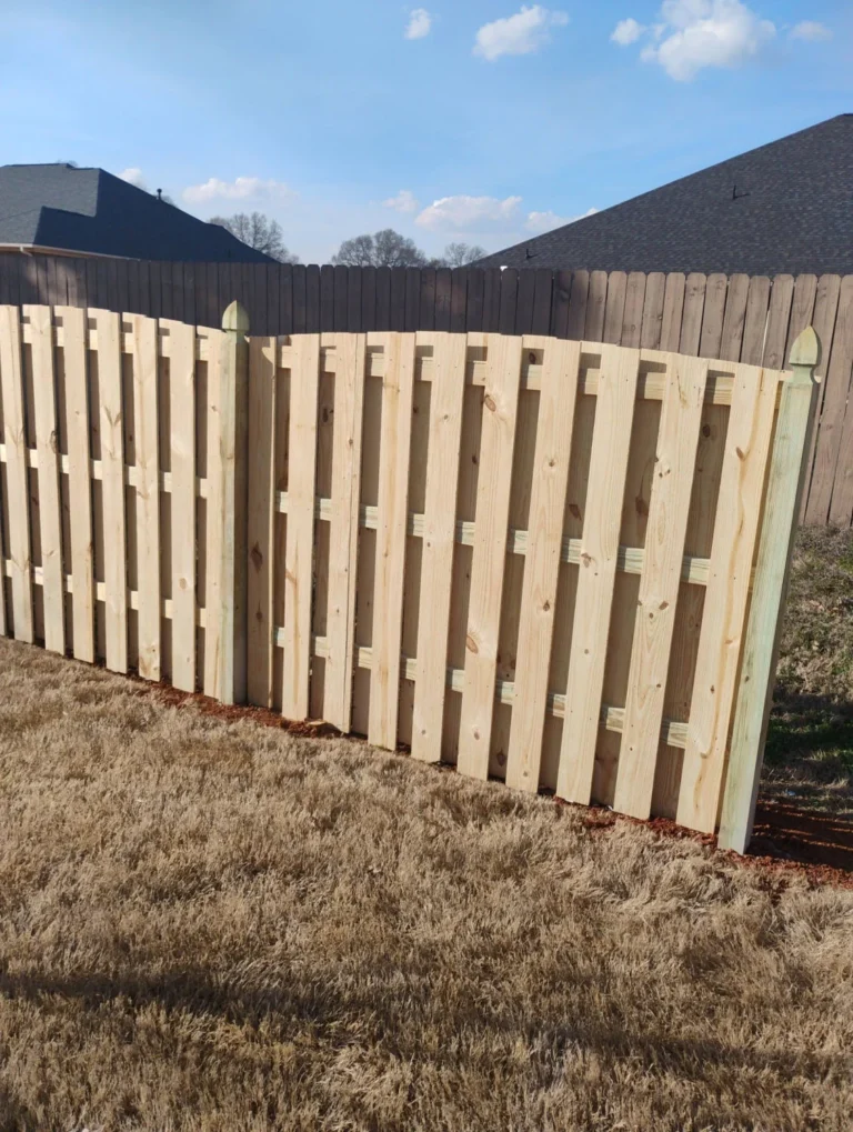 Dog ear wood picket fence along a property boundary