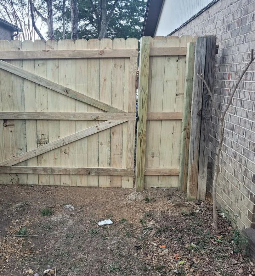 Wood privacy fence with a double drive gate and drop rod